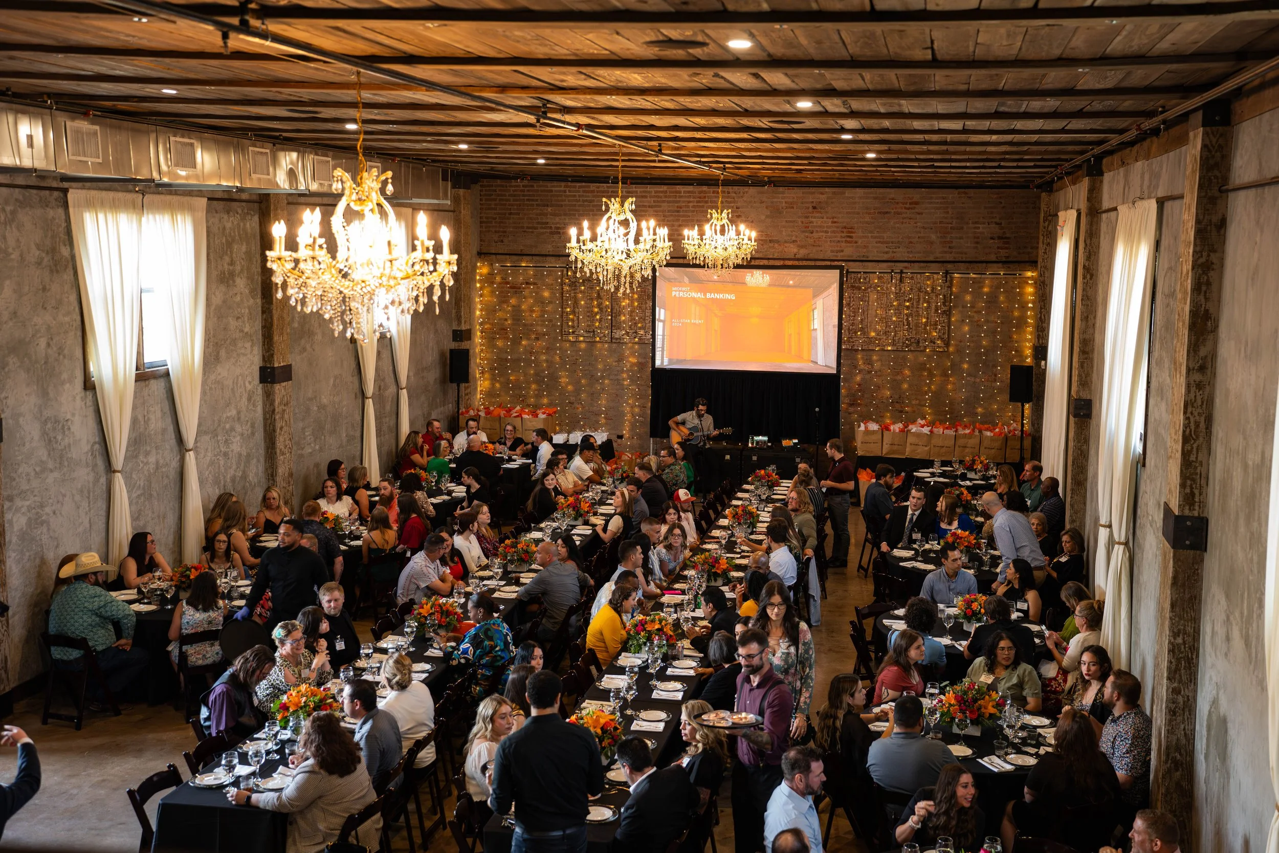 Guests gathered around tables for an event presentation