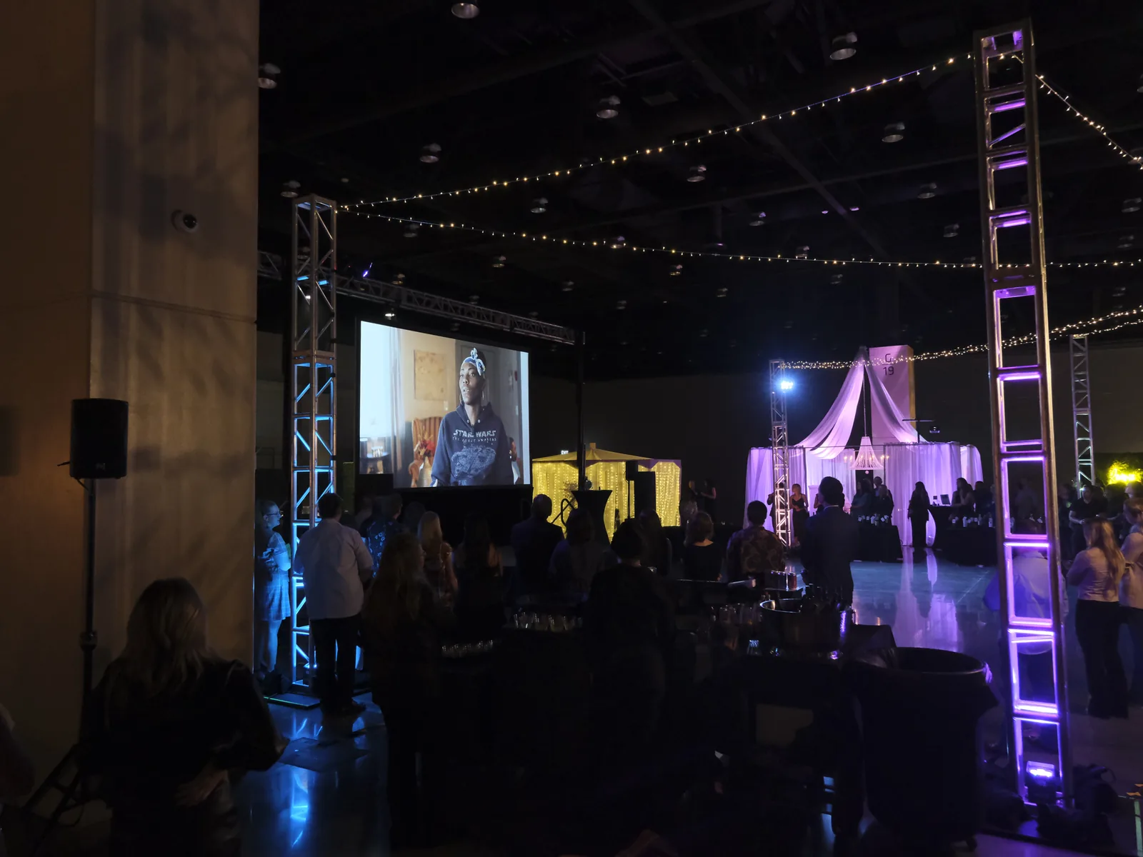 Focus on Home event room with projection, truss, lighting, and guests gathered for the program