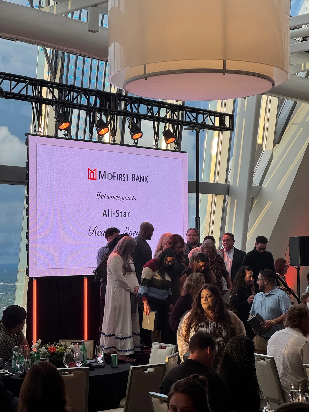 MidFirst Bank employees gathered in front of the All-Star presentation screen